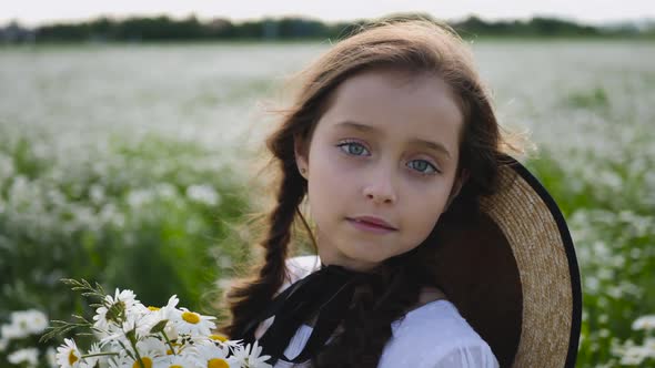 Girl in a White Dress of Seven Years with Big Eyes