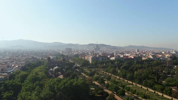 Misty skyline of Barcelona on sunny day, aerial descend view