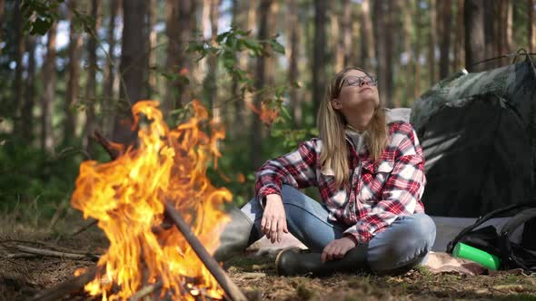 Red Fire Burning in Forest with Happy Woman Stretching at Background