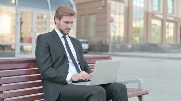 Businessman Leaving Bench After Closing Laptop