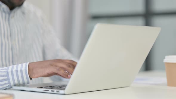 Close Up of African Man Typing on Laptop