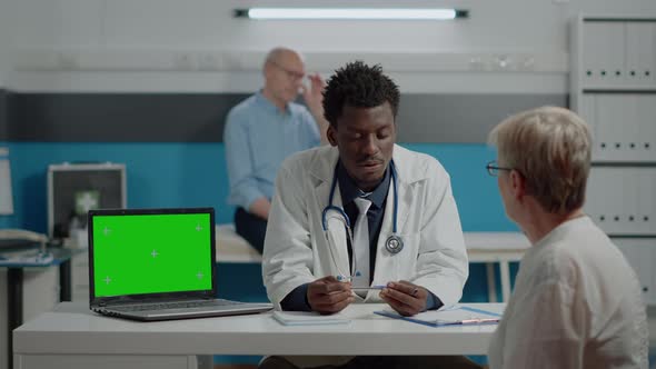 Adult Specialist Talking to Patient with Horizontal Green Screen