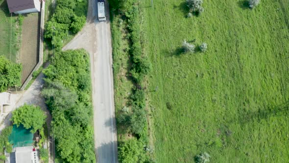 Top Down Aerial View Following a Bus on a Road in a Rural Area