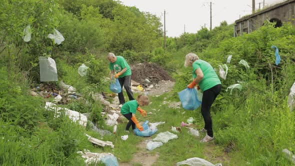 Team of Nature Activists in Eco T-shirts Picking Up Plastic Trash in Park. Recycle, Earth Pollution