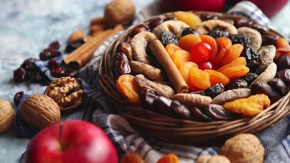 Composition of Dried Fruits and Nuts in Small Wicker Bowl Placed on Stone Table