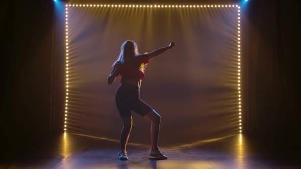 Modern Beautiful Girl Dancing Jazz Funk in a Dark Studio with Back Lights. Silhouette in Slow Motion