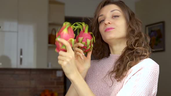 Young Girl is Holding Two Fresh Ripe Organic Dragon Fruits or Pitaya Pitahaya