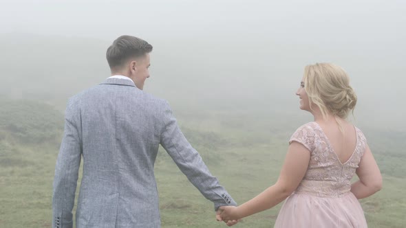 Elegant couple holding hands and walking