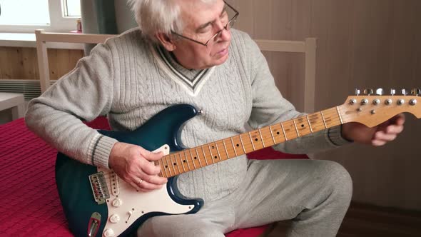 Senior Man is Playing Guitar