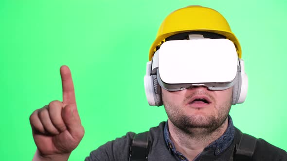 Portrait of a Male Builder in Virtual Glasses on a Green Chromakey Background