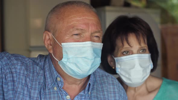 Elderly Family in Face Mask Behind Window