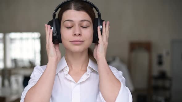 woman puts on headphones, turns on music, closes her eyes and her mood improves