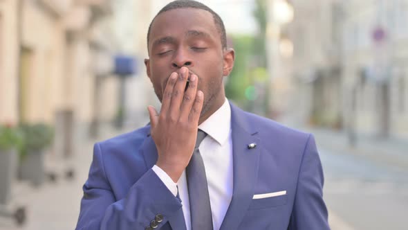 Outdoor Sleepy African Businessman Yawning