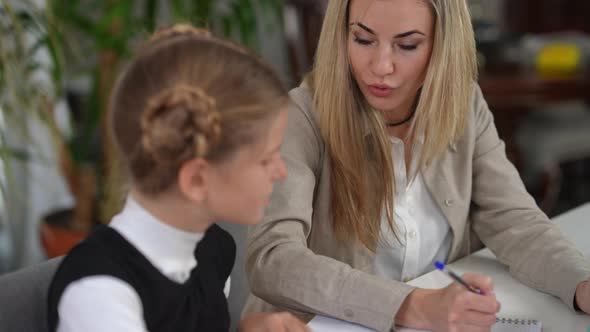 Portrait of Intelligent Beautiful Woman Talking Explaining Material to Teen Student Sitting at Desk alt