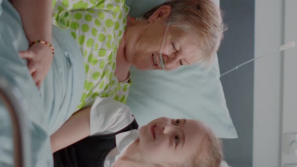 Vertical Video Ill Pensioner Enjoying Visit From Niece and Daughter in Hospital Ward Bed