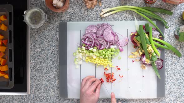 Red Chilli Chopped Into White Cutting Board Along With Other Spices At The Kitchen. - Top-down Shot