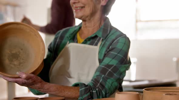 Female potter examining a earthenware pot