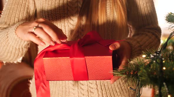 Closeup  Footage of Toung Woman Opening Red Box with Gift and Looking Inside