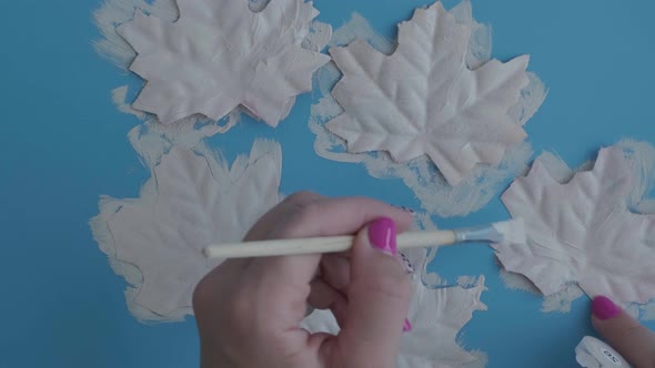 Female Hand Paint on Maple Leaf Face As Decoration for Autumn Halloween Holiday Celebration