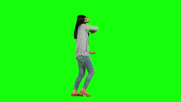 Using Virtual Reality Technology. Girl with Pleasure Uses Head-mounted Display. Green Screen