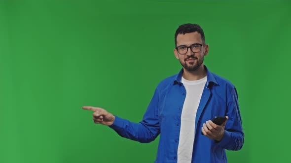 Handsome Man Using Mobile Phone and Pointing Side Over Isolated Background