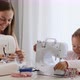 A mother and a daughter are spending time at sewing and talking. Panoramic view. - VideoHive Item for Sale
