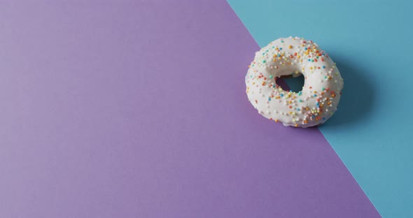 Video of donut with icing on purple and blue background