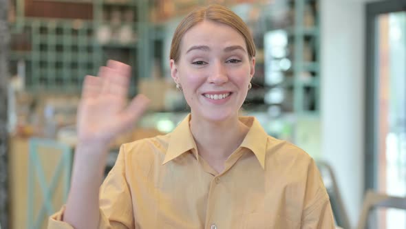 Portrait of Beautiful Young Woman Waving at the Camera 