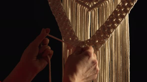 Women's Hands Weave a Macrame Pattern in Creative Workshop on Black Background