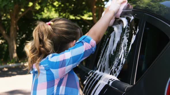 Girl washing her car in the garden