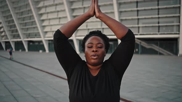 Zoom Out Portrait of Mindful Chubby African American Woman Meditating Outdoors Practicing Breathing