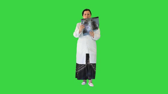 Female Doctor Examining Lungs Xray While Walking on a Green Screen Chroma Key