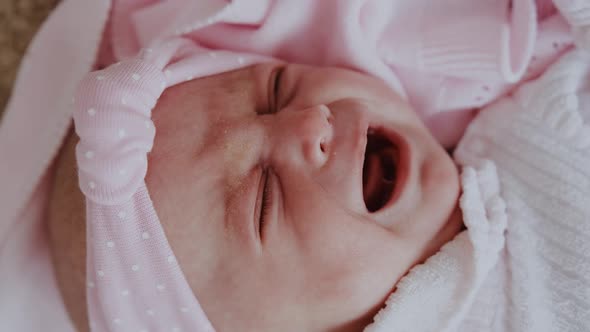 Newborn Baby Girl Lying on Bed Crying Close Up