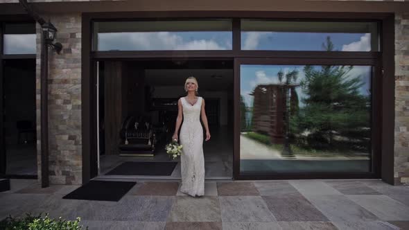 Elegant Bride in a White Gown Leaving a Hotel