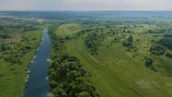 Top View of Green Fields Hills Trees and River Bed