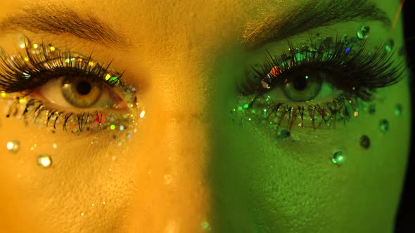 Womens Eyes with Sparkles and Rhinestones, Illuminated with Yellow and Green Neon Light, Look