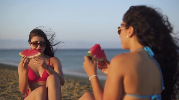 Young Hipster Women Enjoying Watermelon Slice on Beach in Summer