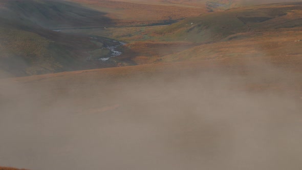 Early morning mist hanging over the Moorlands in the Yorkshire Dales National Park tilt up shot.