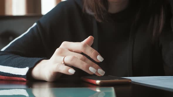 Young Woman Use Mobile Phone While Sitting in Comfortable Coffee Shop During Work Break