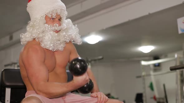 Santa Claus with Dumbbells in the Gym