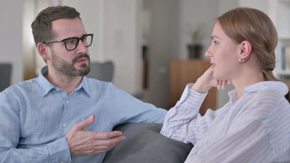 Portrait of Serious Young Man Having Conversation with Woman 