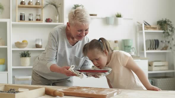 Grandmother and Her Granddaughter Enjoying Smell of Handmade Cookies