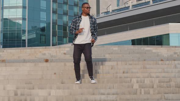 Stylish African American Man Guy Model Dancer Wears Plaid Shirt and Sunglasses Walking Up Stairs in