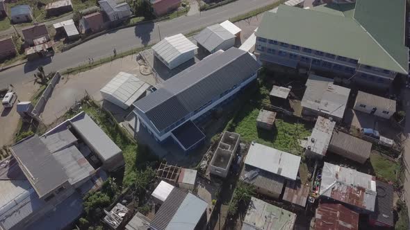 Low aerial flight over primary school in African township, Knysna