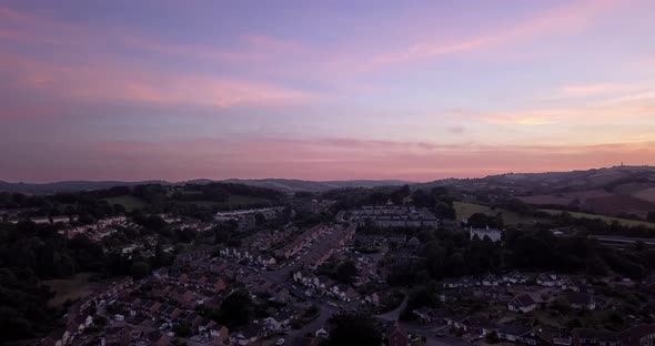 Aerial, flying over the charming city of Exeter, England, during a pink and purple sunset