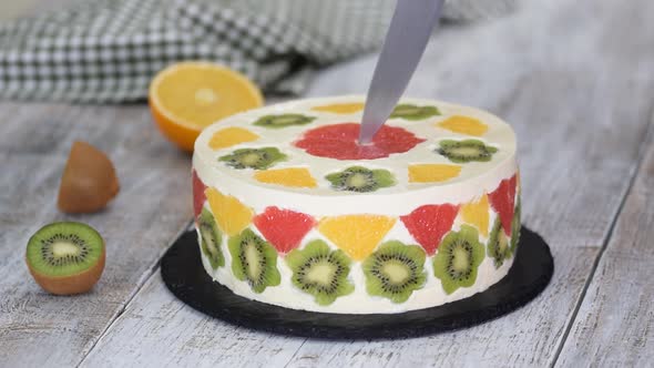 Woman Cuts a Delicious Fruit Mousse Cake