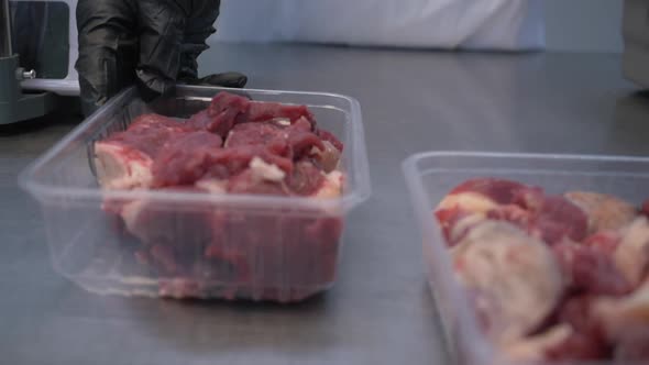 Worker in Black Proective Gloves Prepares Fresh Meat for Delivery to Stores