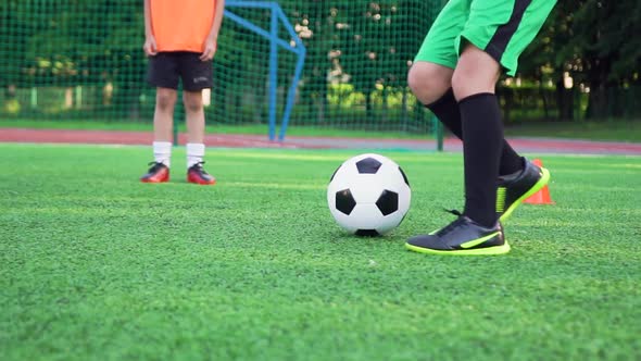 Boy's Feet in Football Shoes which Working with Ball During Training