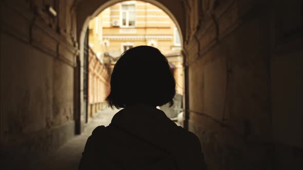 Silhouette of a Beautiful Girl Passing Through the Arch