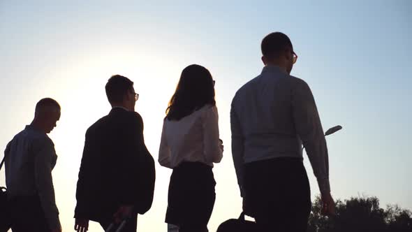 Group of Young Businessmen Walking in City Street at Sunset Time. Colleagues Being on His Way To